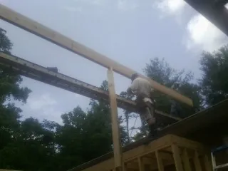 Carpenter setting a ridge beam over a new addition frame — Ice Dam Removal by Roofing Brothers in Blue Bell