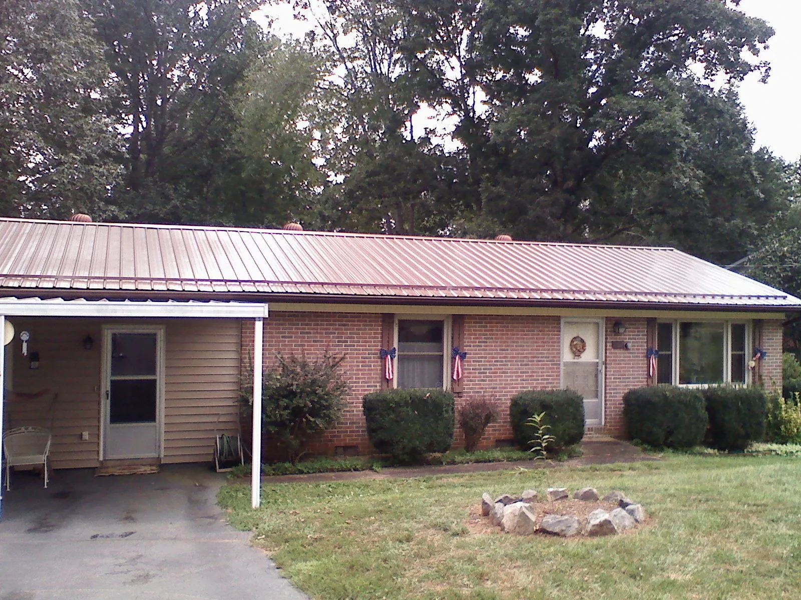 Bronze metal roof and carport on a brick ranch home — Roof Repair work by our crew in Blue Bell